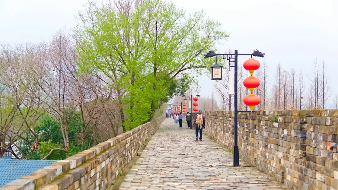 Walkers on top of Nanjing's Ming-era city wall beside red lanterns