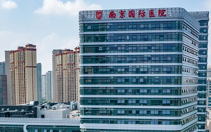The Nanjing International Hospital tower, its Chinese name mounted along the top of a wide glass facade.