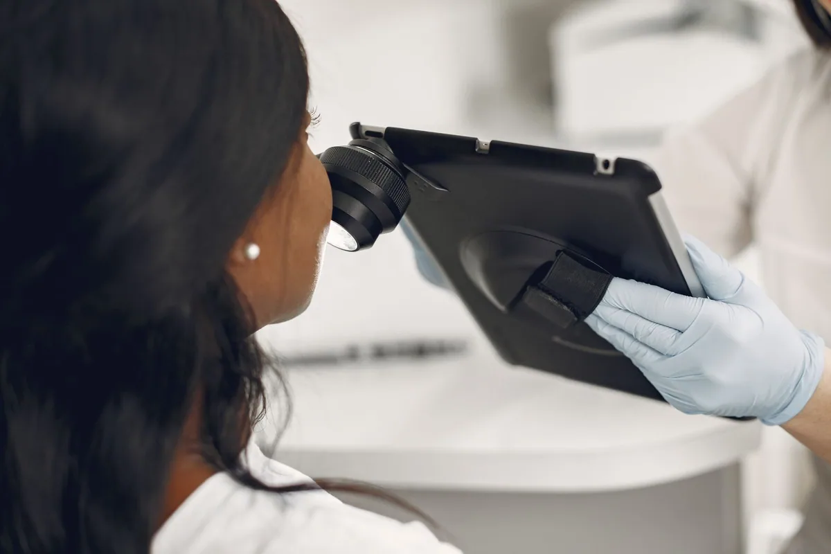 A physician examining a patient's skin with a dermatoscope.